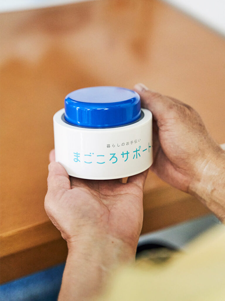 マゴコロボタンを手に載せるシニアの手元アップ