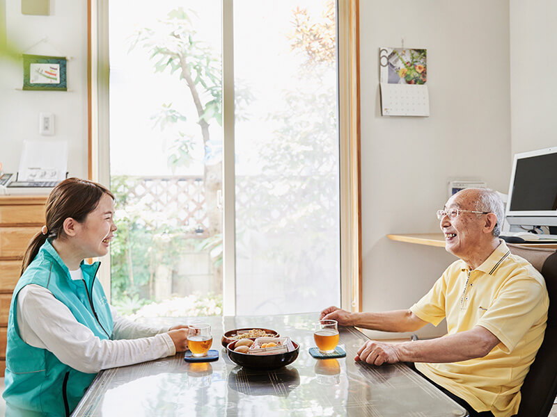 笑顔で会話するスタッフとシニア男性